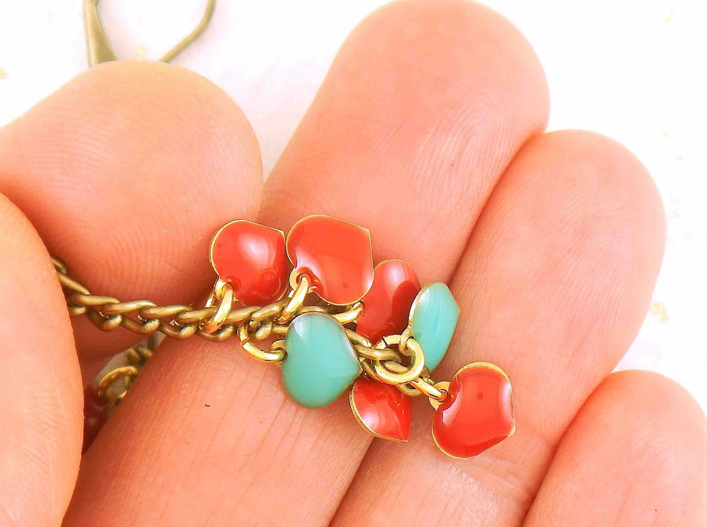 Long earrings with 7 small cascading red and turquoise enamelled brass hearts, aluminum chain, brass lever back hooks