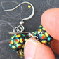 Short earrings with tiny crystal disco balls in golden green, stainless steel hooks