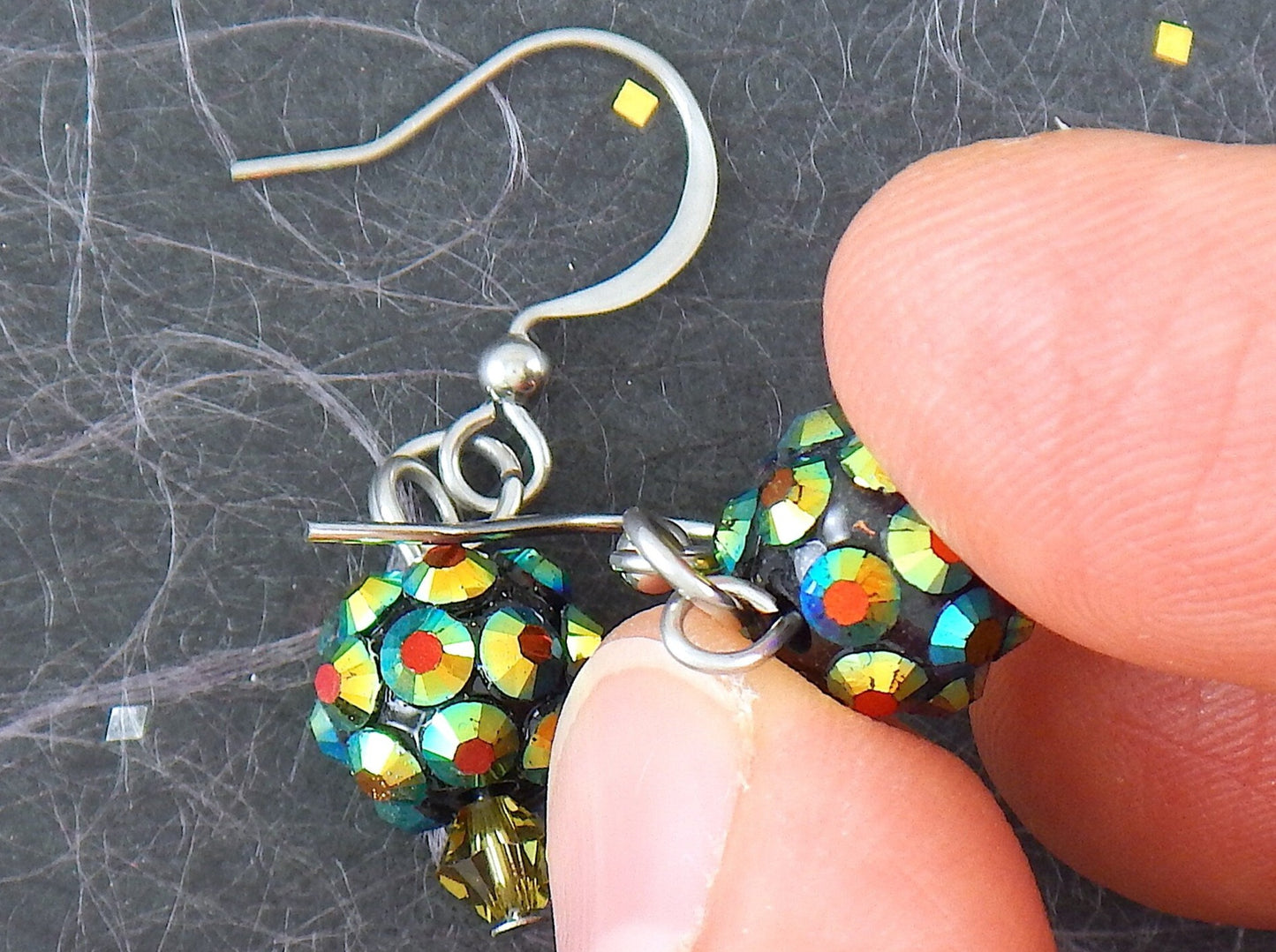 Short earrings with tiny crystal disco balls in golden green, stainless steel hooks