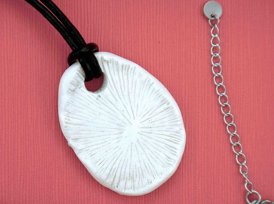 22-inch necklace with off-white ceramic coral pendant handmade in Montreal, black leather cord, stainless steel clasp