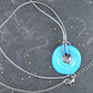 19-inch necklace with round turquoise and dark silver ceramic pendant handmade in Montreal, dark silver gray leather cord, stainless steel clasp
