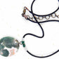 20-inch necklace with green-caramel-white oval jasper pendant on black satin cord, antique glass cylinder beads, brass clasp