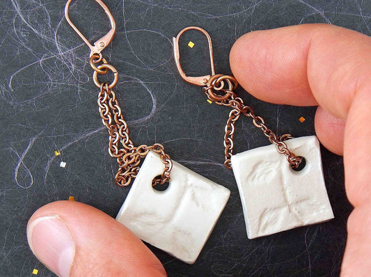 Very long earrings with off-white ceramic lozenges handmade in Montreal, leaf pattern, rose gold plated stainless steel lever back hooks