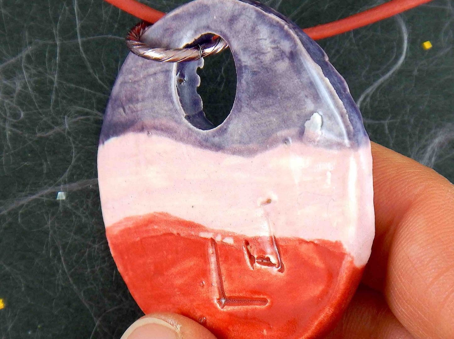 Collier 16 po à grand pendentif de faïence rond vagué violet-rose-rouge fait à la main à Montréal, cordon de cuir rouge, anneau aluminium, fermoir acier inoxydable
