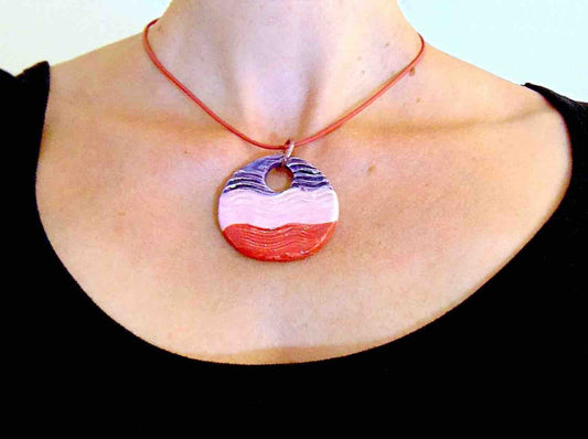 16-inch necklace with large round wavy ceramic pendant medallion handmade in Montreal in violet-pink-red, red leather cord, aluminum ring, stainless steel clasp