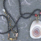 17-inch agate slice pendant in burgundy-white-gray on black satin cord, antique glass cylinder beads, copper clasp
