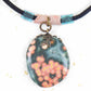 20-inch forest green oval jasper pendant with coral pink dots, black satin cord, antique glass cylinder beads, copper clasp