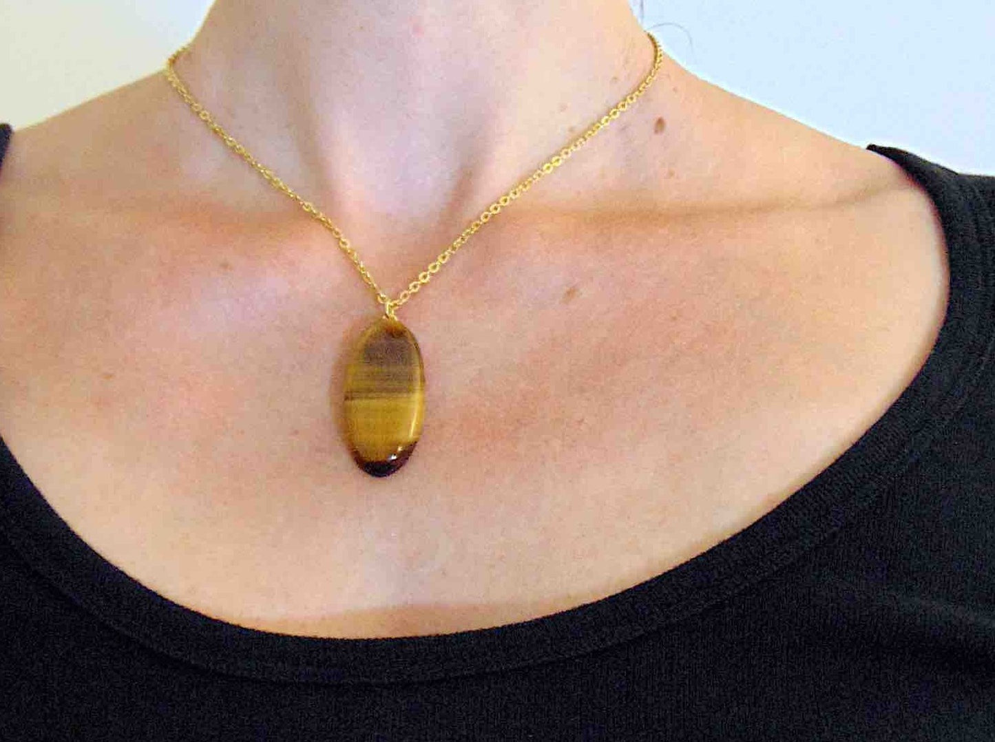 16-inch necklace with oval golden brown tiger eye stone pendant, horizontal pattern, gold-toned stainless steel chain