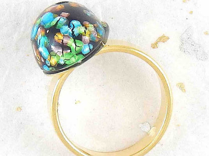 Finger ring with black oval vintage glass cabochon, blue-green-gold speckled, gold-toned stainless steel adjustable base