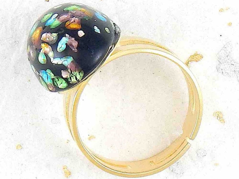 Finger ring with black oval vintage glass cabochon, blue-green-gold speckled, gold-toned stainless steel adjustable base