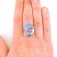 Finger ring with hand-painted blue-pink-gold-black oval vintage glass cabochon, abstract flower pattern, gold-toned stainless steel adjustable base