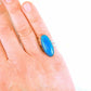 Finger ring with bright turquoise long oval vintage glass cabochon, butterfly wing pattern, adjustable stainless steel base
