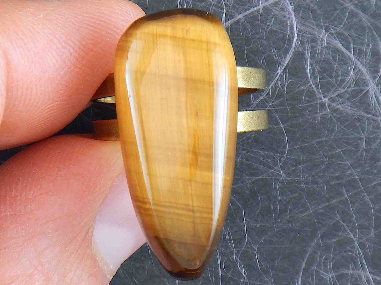 Finger ring with long drop-shaped golden tiger eye stone cabochon, adjustable brass base (US 5-6)