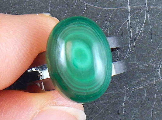 Finger ring with small oval malachite stone cabochon, concentric dark and light green rings, black nickel metal adjustable base (US 5-6)