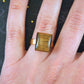 Finger ring with rectangular golden tiger eye stone cabochon, gold-toned stainless steel adjustable base (US 7-8)