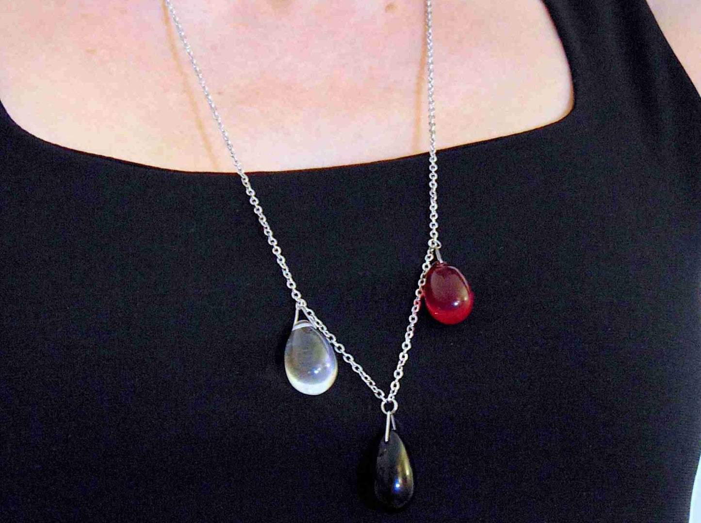 28-inch asymmetrical necklace with 3 glass drops (translucent red, opaque black, iridescent clear), hypoallergenic stainless steel chain