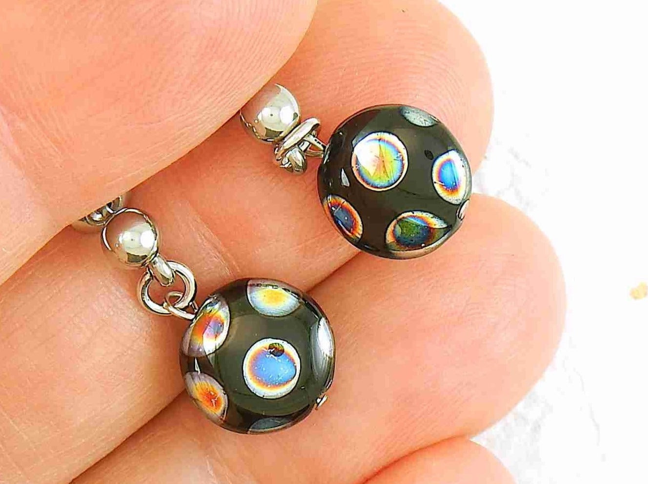 Short earrings with small shiny black round Czech glass pebbles, small multicoloured dots, stainless steel posts