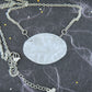 18-inch necklace with large oval matte vintage crystal pendant, sculpted on both sides (Lalique-style flower and leaf pattern), stainless steel chain